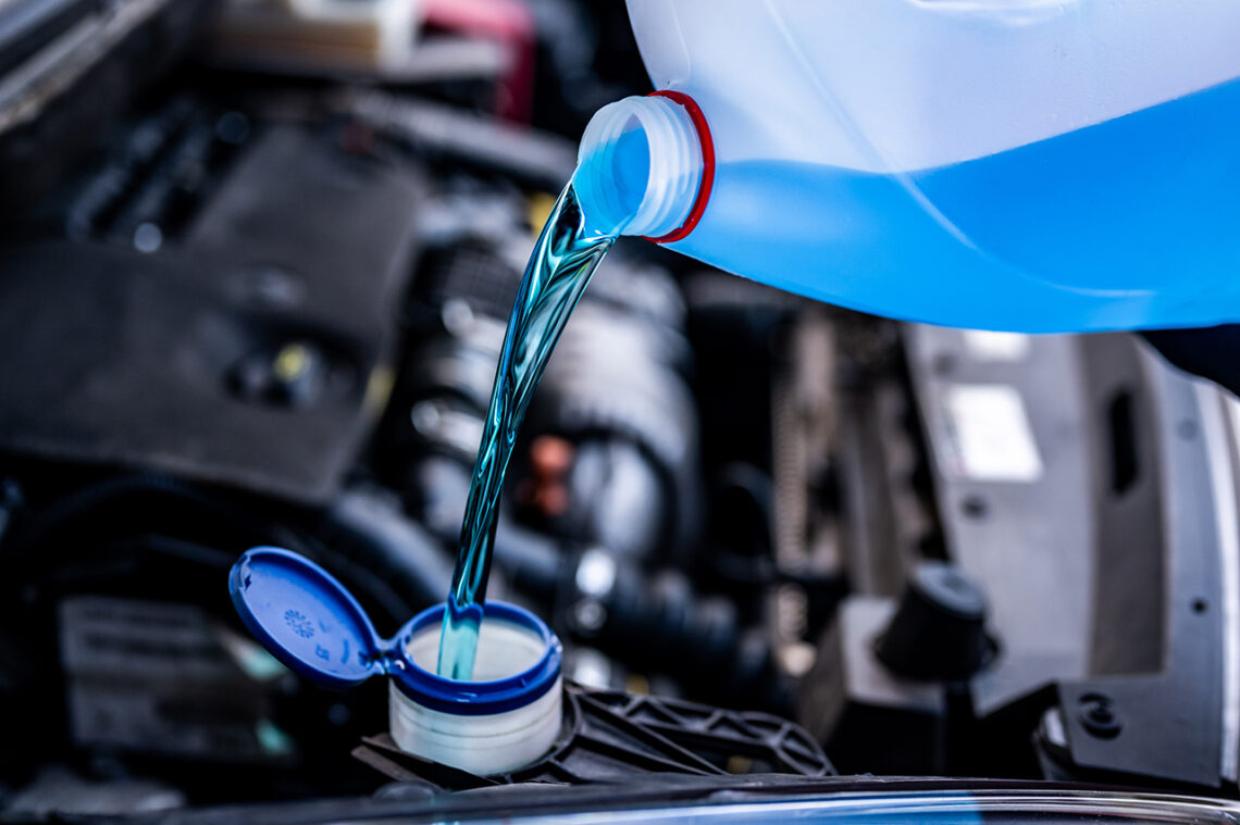 Alfa Romeo service technician filling windshield wiper fluid