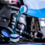 Alfa Romeo service technician filling windshield wiper fluid